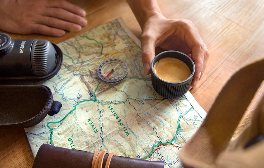 Zaparzone espresso w kubku obok ekspresu Nanopresso położonego na mapie turystycznej.